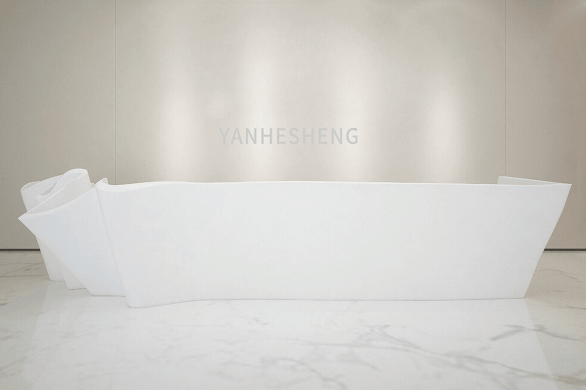 Side view of curved white solid surface reception desk for modern lobbies with seamless acrylic solid surface finish
