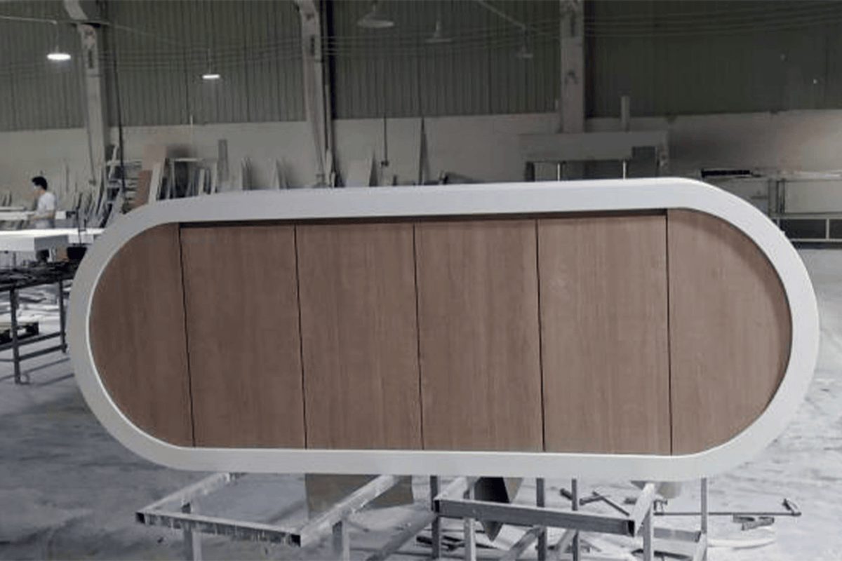 Side view of curved white solid surface manager desk for executive workspaces with seamless acrylic solid surface finish