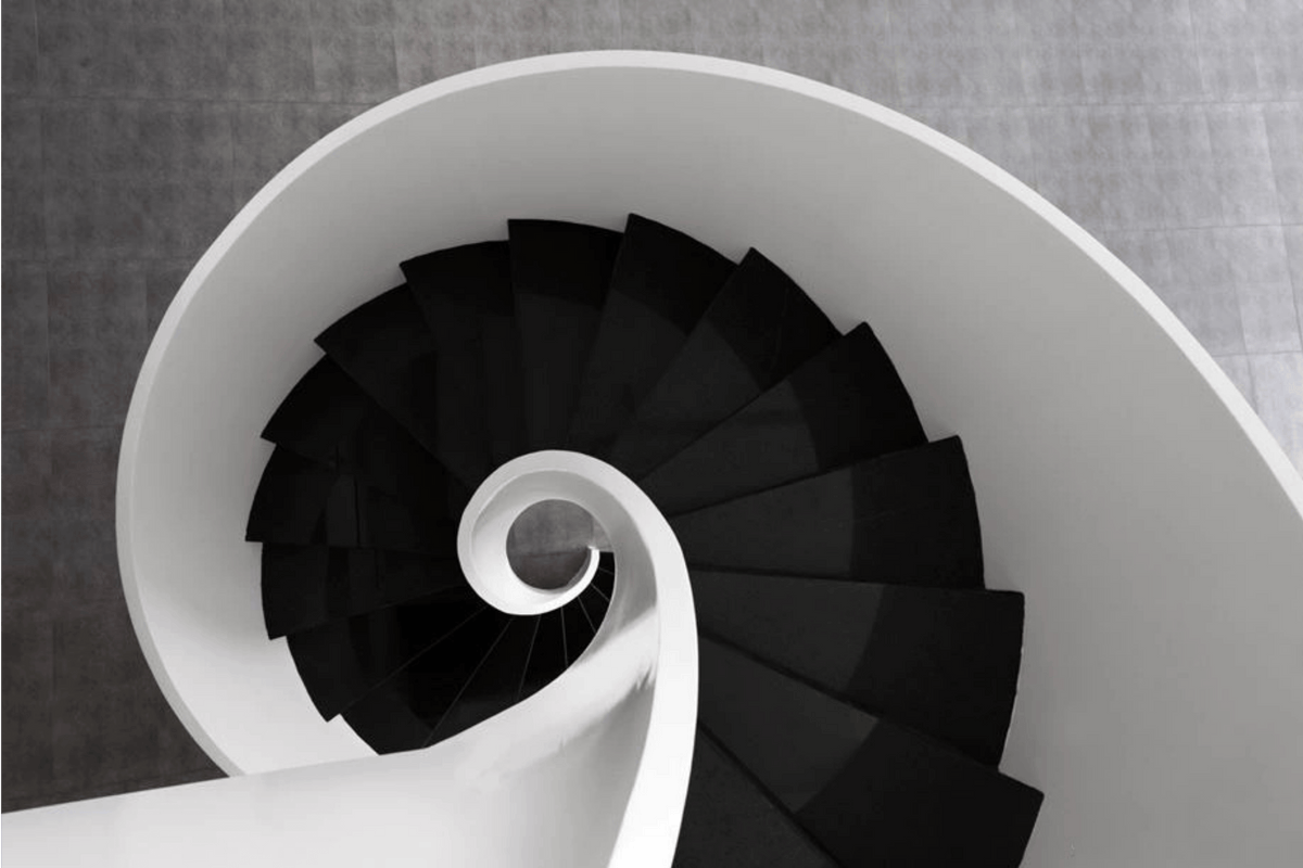 Side view of minimalist black and white solid surface spiral staircase with seamless acrylic solid surface finish