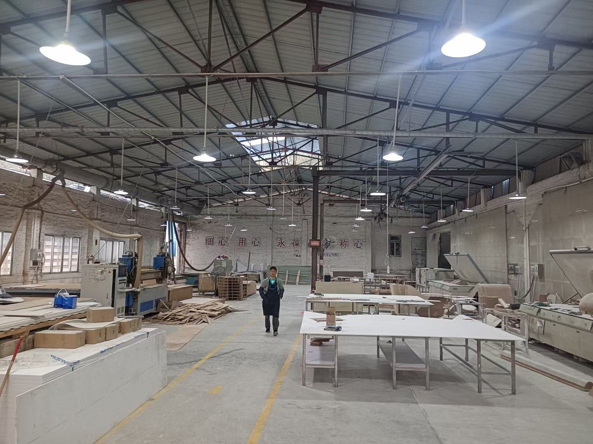 Solid surface furniture production workshop with worktables and fabrication equipment