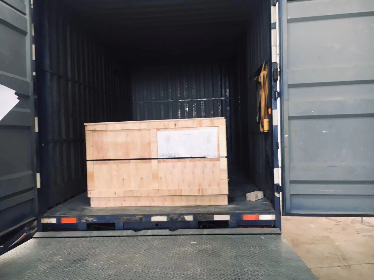 Wooden shipping crate positioned at the open rear of a delivery vehicle